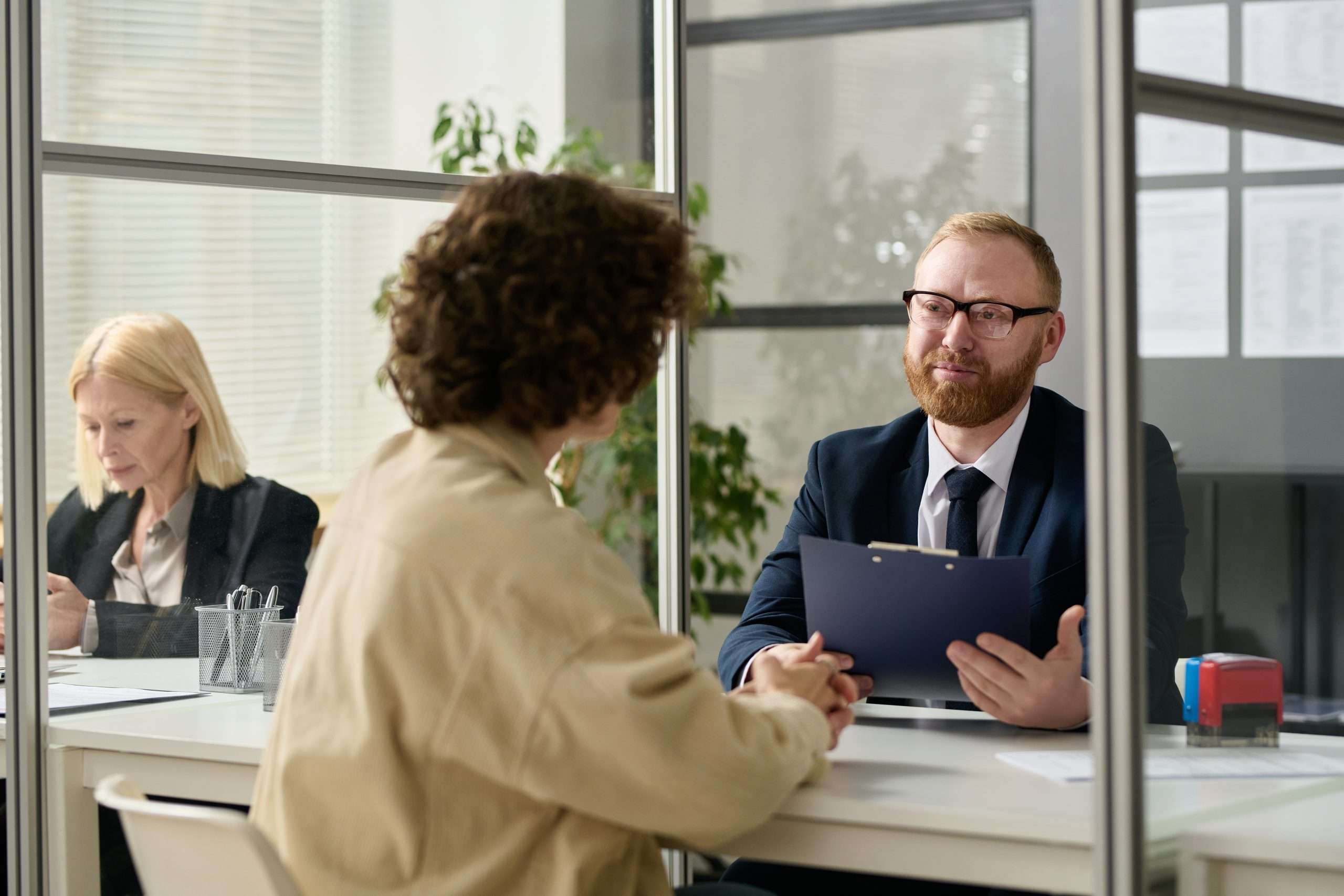 Consultant talking to woman in cubicle at agency office