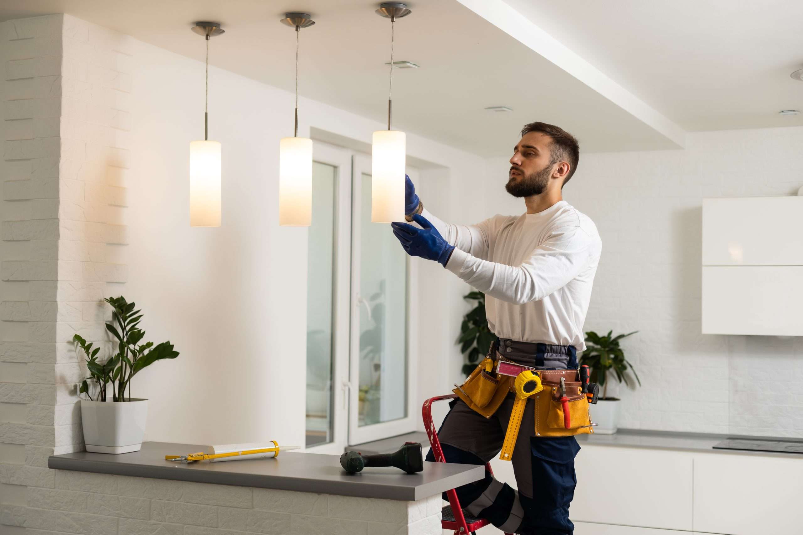 Electrician installs lamp lighting and spot loft style on ceiling.